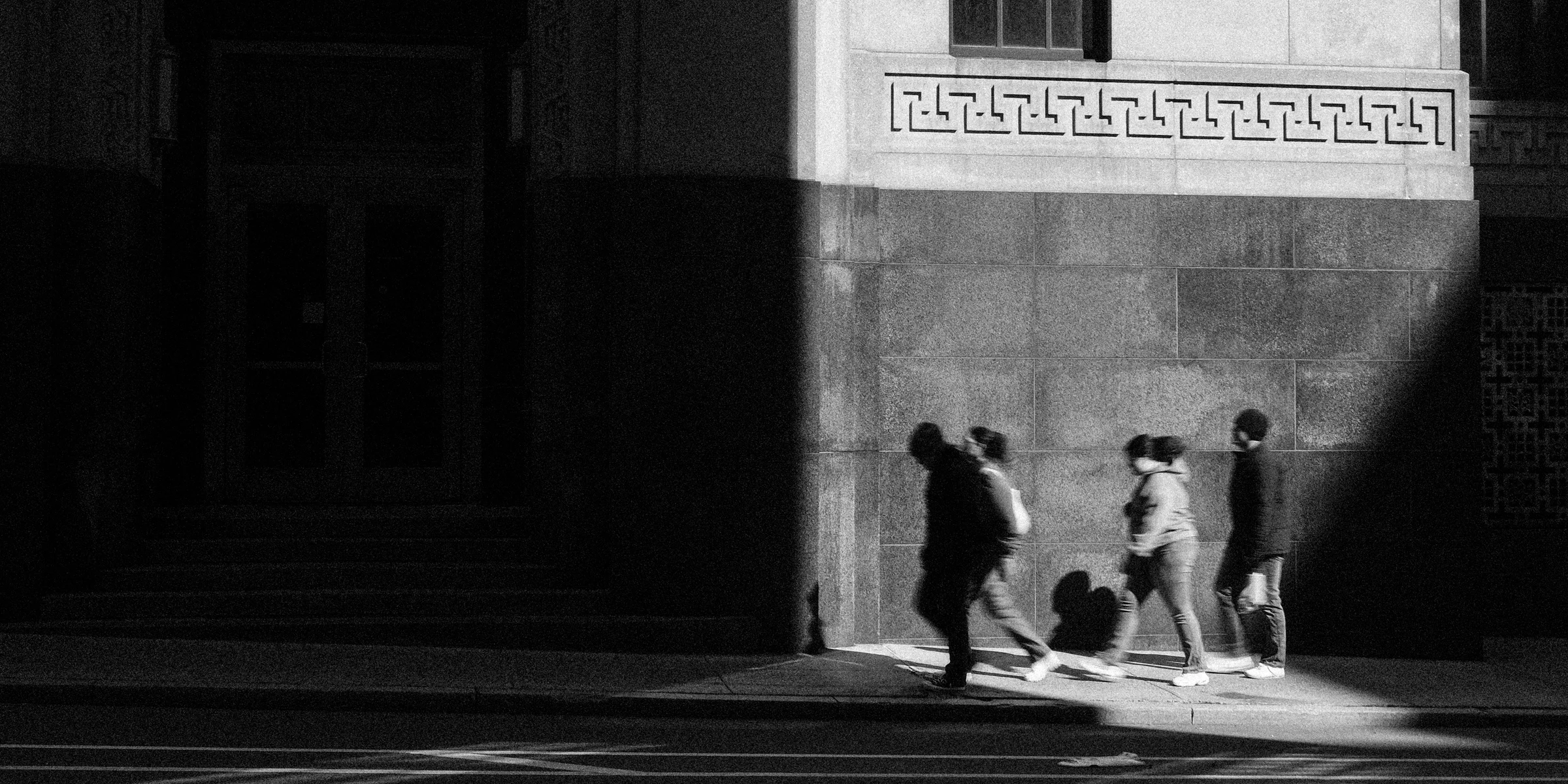 Three figures silhouetted in a pool of light